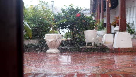 Vista-De-La-Lluvia-Cayendo-Pesadamente-Dentro-De-Una-Casa-Colonial