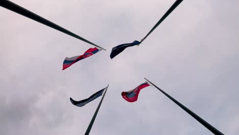 slovakia and european union flags next to each other fluttering in wind on flagpole, slow motion bottom view