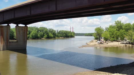 bridge spanning a river with a reveal of a park from a aerial view