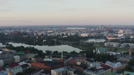 Aerial-Helsinki-city-skyline-with-river-bridges-towers-trees-colorful-buildings