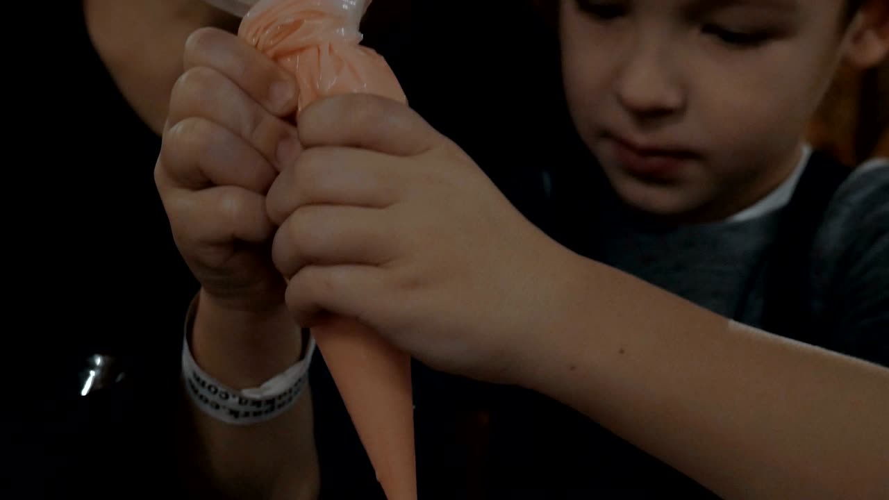 madre y niño decorando galleta de pan de jengibre con helado