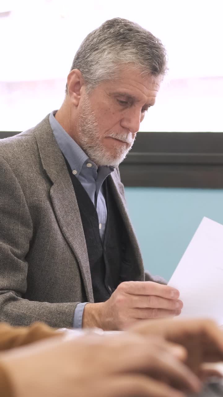 Manager che analizza documenti e usa il computer in uno spazio di coworking