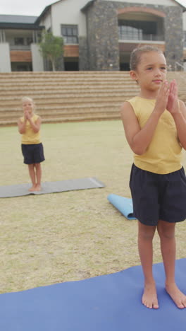 video vertical de niñas felices y diversas haciendo ejercicio en la escuela