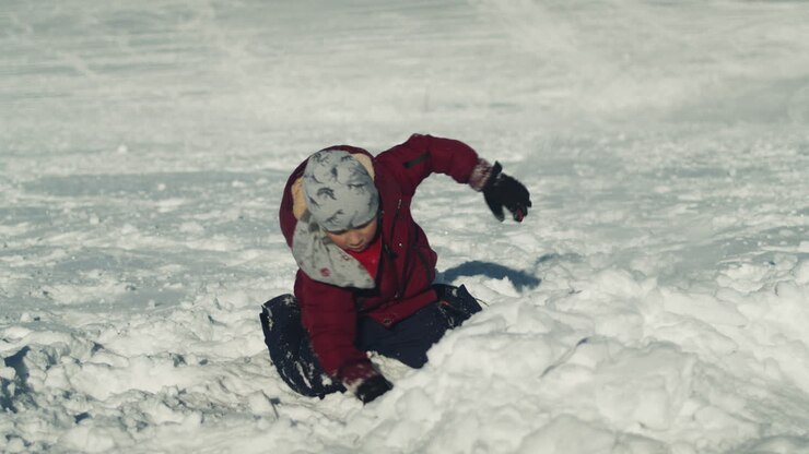 Energetic Little Boy Digs in Snow with Hands and Sits Back to Look Around