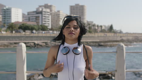 retrato de una joven mujer hispana bailando juguetona disfrutando de las vacaciones de verano en una hermosa playa