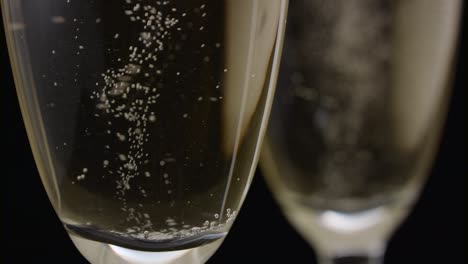 champagne glasses with champagne rotating on a black background champagne glasses with champagne rotating on a black background concept celebrating time new years eve valentines day