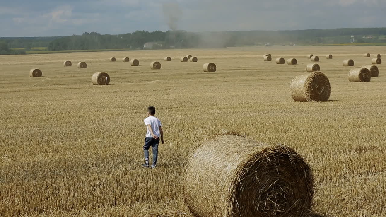 Child Boy In The Field. Child boy in the field against straw bales