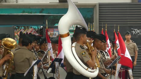 a marching band made of peruvian policemen and women. some hold peruvian flags, one holds a big tuba, others drums and more instruments.