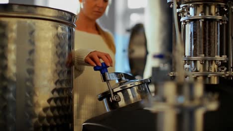 female worker checking distillery tank 4k