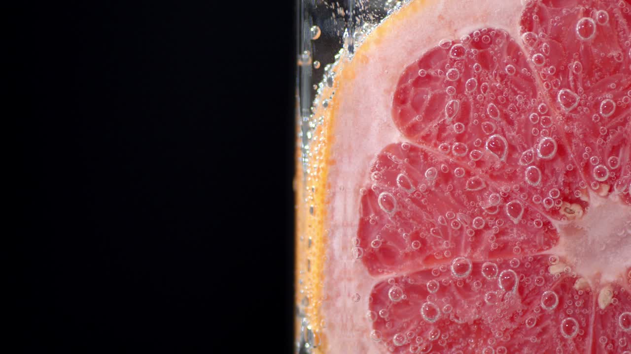 Ein Stück Grapefruit unter Wasser mit Luftblasen