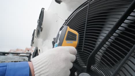 technician uses a thermal imaging infrared thermometer to check the condensing unit heat exchanger