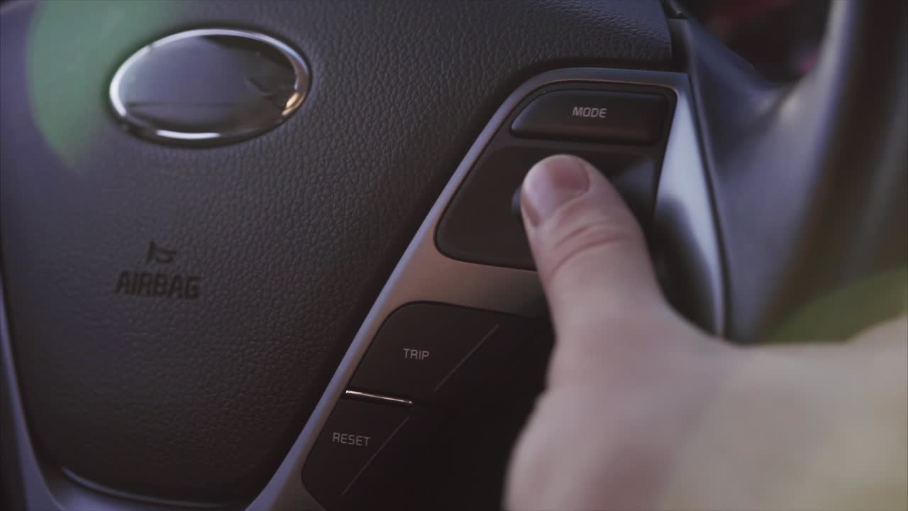 persona que utiliza los controles del volante del automóvil