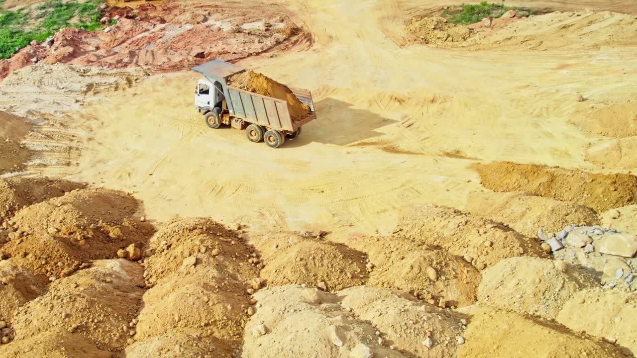truck driver dumping sand at one place in construction area in telangana, india. day time, drone shot, 4k