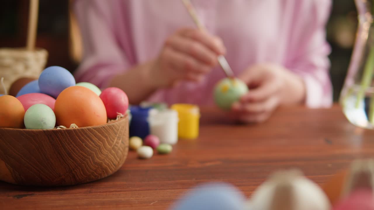Happy Easter holiday. Coloring eggs close-up. Woman preparing for Easter, painting and decorating eggs. Christian celebration, family traditions.