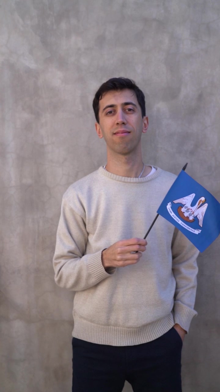 Persona ondeando la bandera estatal de Luisiana. Toma vertical. Concepto de estados de EE. UU.