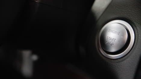 close-up of pressing the engine start and stop button on a modern keyless vehicle