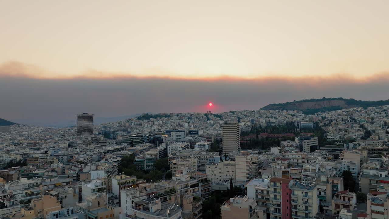 Aerial establishing of Athens skyline at dusk as wildfire smoke blankets sky in haze