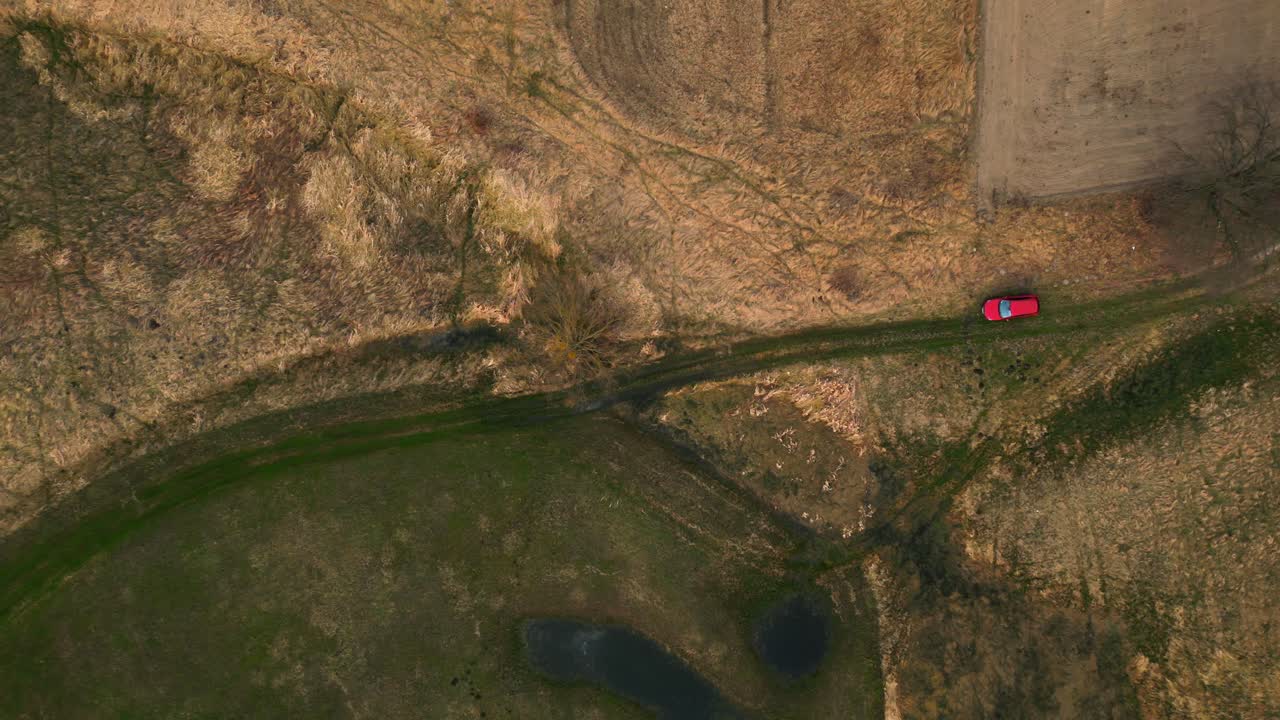 풍경의 항공 사진, 봄 초원에 주차된 빨간 차에 대한 머리 위의 관점