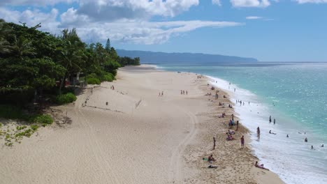 Tourists-on-vacation-bathing-and-having-fun-enjoying-summers-day-on-sandy-beach-of-North-Shore-Oahu,-Hawaii-island