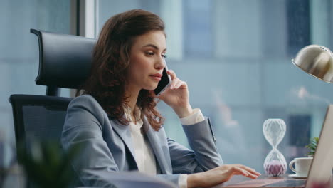 busy woman employee calling sitting office desk looking laptop monitor close up.