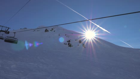 in motion on a ski chair lift in the mountains the sun shines and sunset