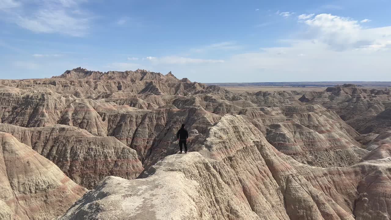 남다코타주 배들랜드 국립공원의 산꼭대기에 도달한 모험가 관광객.