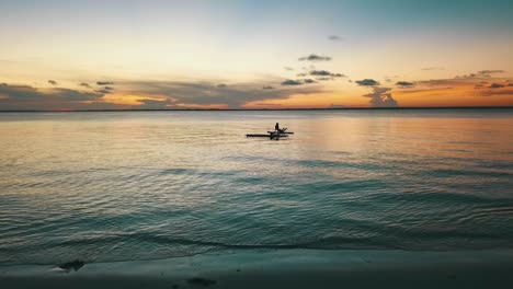 calmer slow motion aerial flight fly forwards drone shot at sunset over surver stand up board