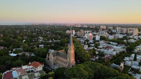 aerial dolly out of san isidro cathedral and buenos aires city on background at sunset