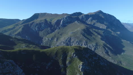 Aerial---Drone-pulls-away,-and-reveals-unique-sandstone-mountains,-scenic-view