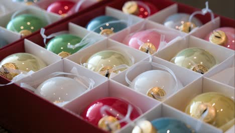 shiny vibrant and colorful christmas tree balls are seen packed in a box