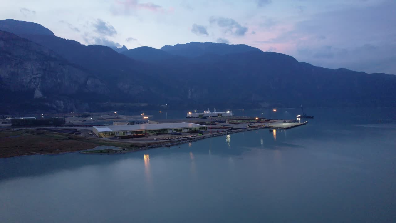 밤에 불이 켜진 스쿼미시 침 보호 구역 항구의 공중 전망, 멋진 일몰 바다 위를 드론 비행