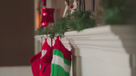 christmas stockings hang from a decorated mantel