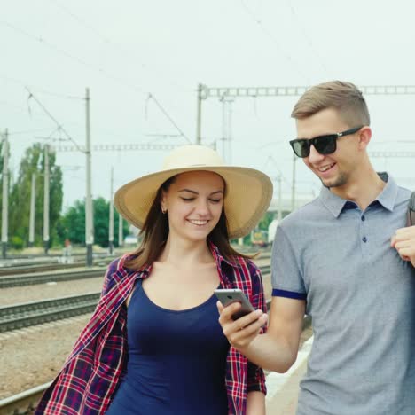 a young couple with bags goes on the platform at the station 2