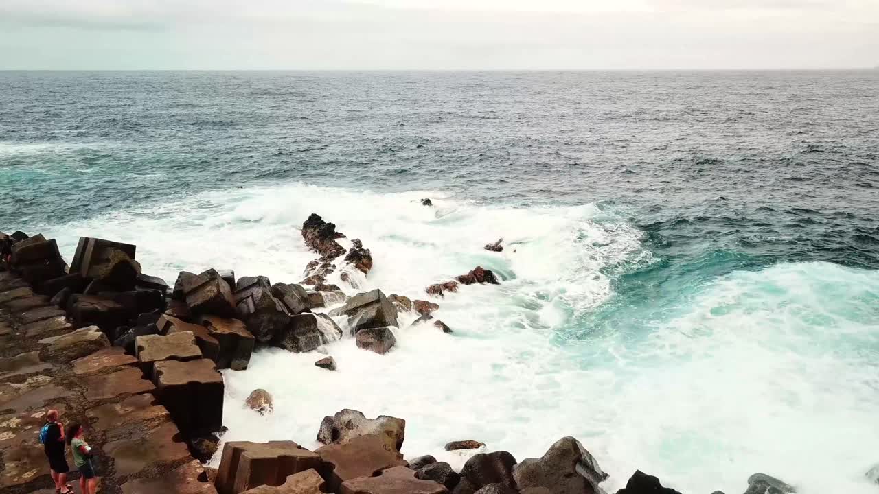 Foaming ocean waves crashing against rugged rocky coast of Seixal, northern Madeira Island, Portugal, create stunning seascape, showcasing nature's raw power, slow motion shot