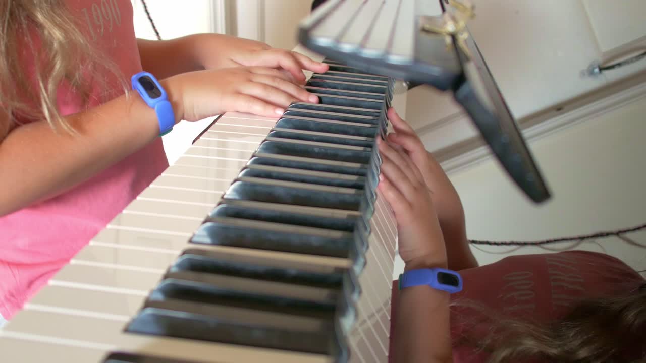 niña aprendiendo a tocar el piano brazos y manos de tiro medio