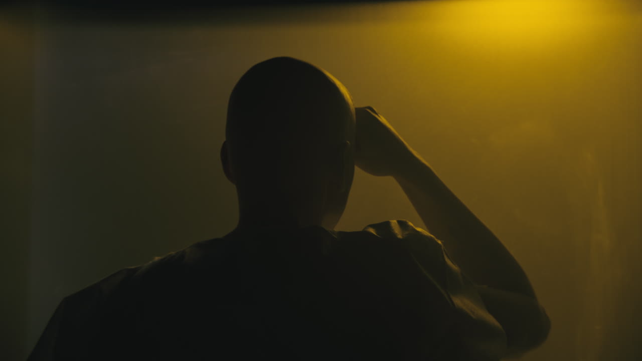 A bald man looks through the yellow glass in the operation room