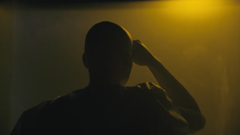 a bald man looks through the yellow glass in the operation room