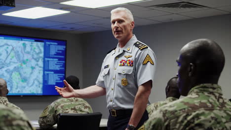 military officer leading a briefing for soldiers