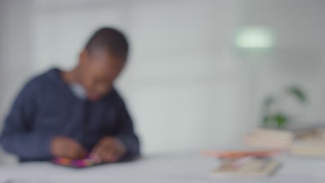 Tiro-Desenfocado-De-Niño-En-Espectro-Asd-En-Casa-Resolviendo-Rompecabezas-De-Forma-Sentado-En-La-Mesa