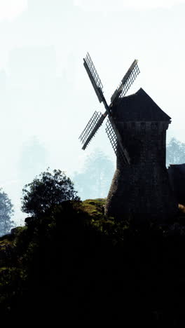 windmill on a hill in the fog