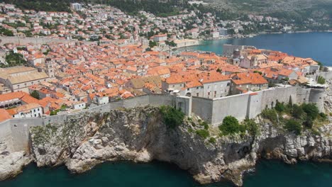 drone aereo sparato sopra la città vecchia di dubrovnik circondata da alte mura in croazia lungo il lungomare durante il giorno soleggiato