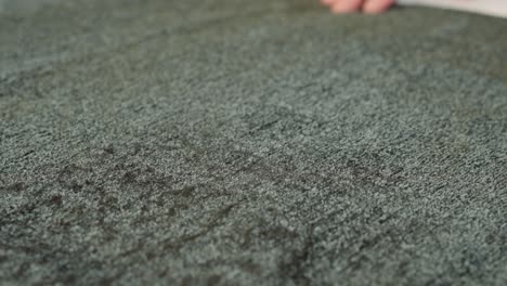 a carpenter rubs his hand through the damaged fabric of a large upholstery sofa cushion