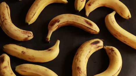 Eine-Makroaufnahme-Reifer-Gelber-Bio-Bananen,-Die-Sich-Vor-Schwarzem-Hintergrund-Drehen