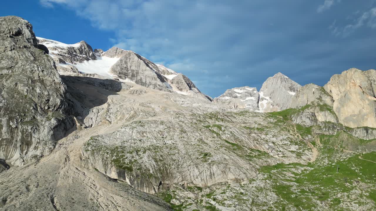 una pista de esquí en el lago di fedaia se extiende a través de escarpados picos de dolomitas bajo un cielo azul brillante, dolomitas, italia