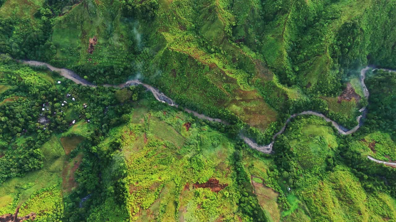 Cinematic 4K aerial of a winding river cutting through lush green mountain valley. Perfect for documentaries, travel promos, nature films, and environmental storytelling