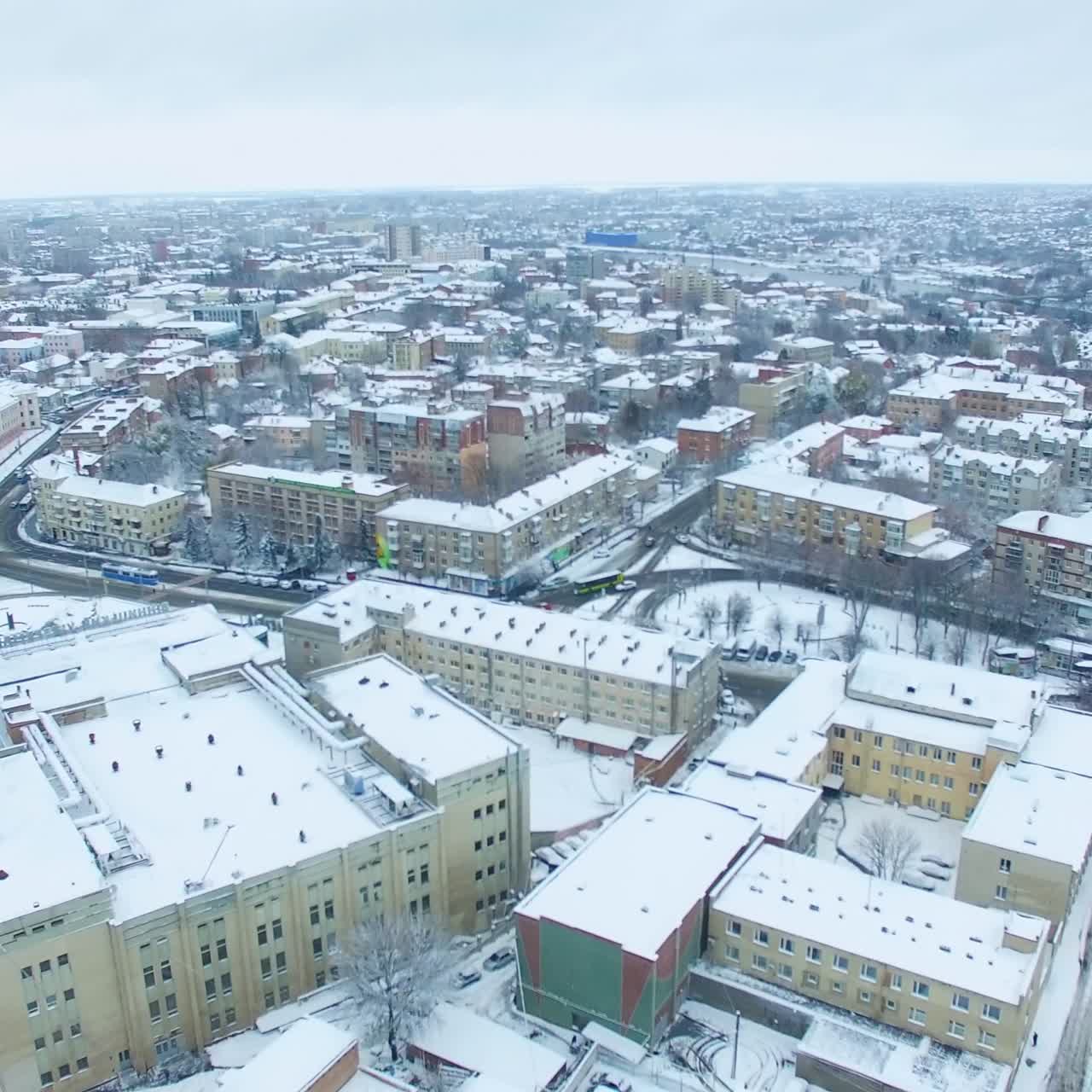 Beautiful view of the busy city on winter season. Building tops are covered with snow. Aerial perspective