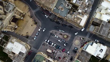 slow descend zoom-in to a roundabout intersection in mediterranean city area suburbs, infrastructure in southern europe