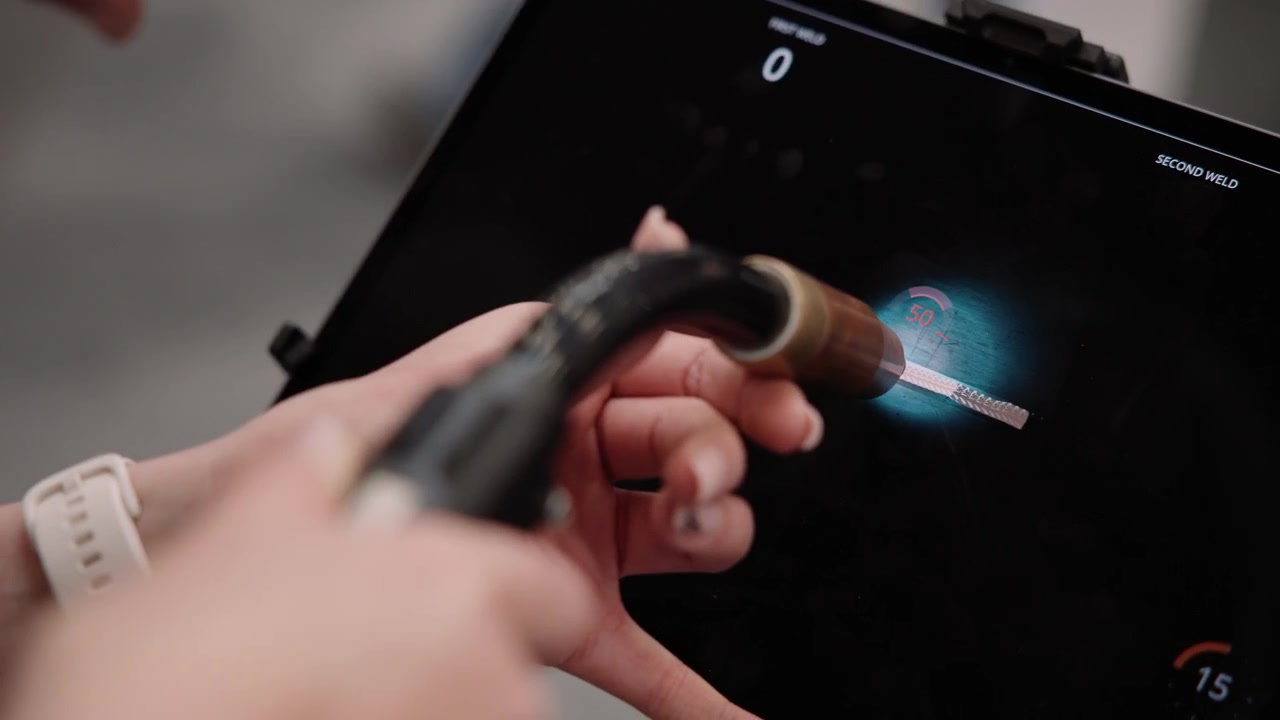 Playing a welding simulator game at an exhibition