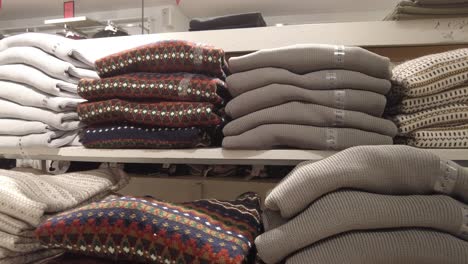 a stack of sweaters for sale in a clothing store