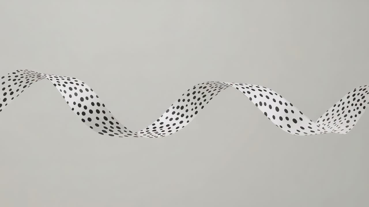 Cresta sinistra sollevata, nastro bianco a pois che si muove verso destra su sfondo grigio, mostrando la parte inferiore